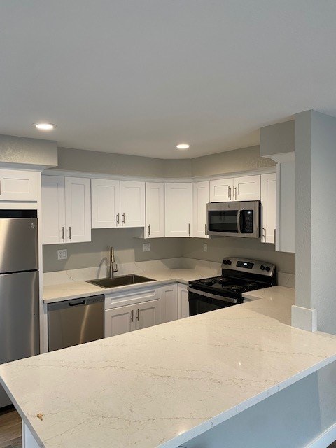 A kitchen with white cabinets and a marble countertop.